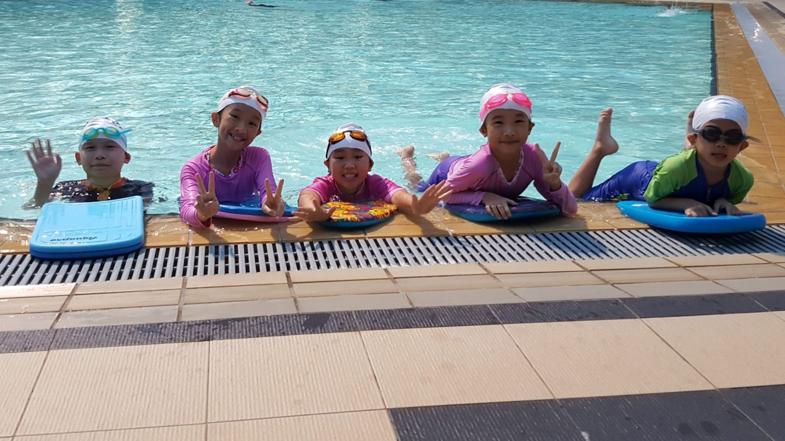 SwimBest students with their swimming boards at the pool